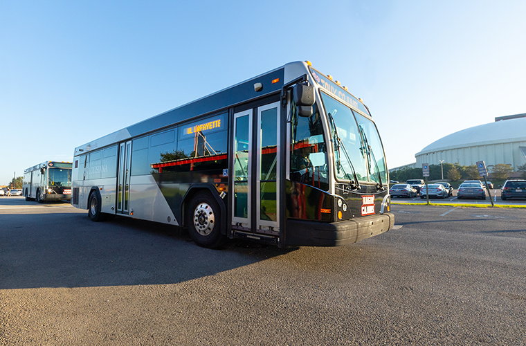 Grey, black and red UL Lafayette bus waits for students outside of Cajun Field